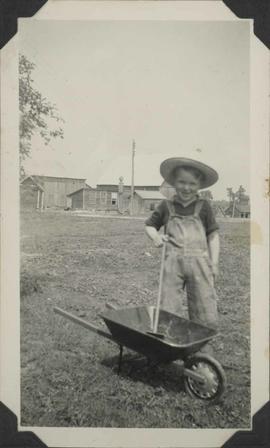 Child with wheelbarrow and hoe