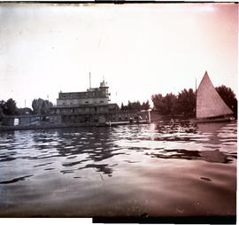 [View of hotel from river with sailing skiff]