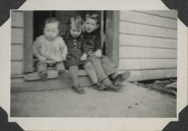 Three children sitting on step