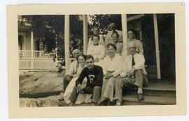 Photo of four gentlemen and six ladies sitting and standing of a porch