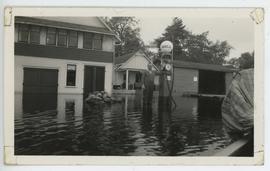 Man holding gas pump at Mooney's Store during flood in June of 1943, Ivy Lea