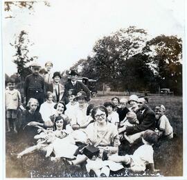 3-1/2 x 3-1/2 snapshot about 25 people sitting  and standing in a field, labelled on the album pa...