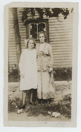 Two ladies standing in front of house