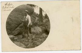 Post card of man standing by rock, inscribed 8/15/06 Esteo Park, Colorado