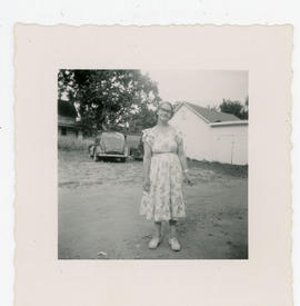 Woman standing with buildings and cars in background, inscribed “Irene”.