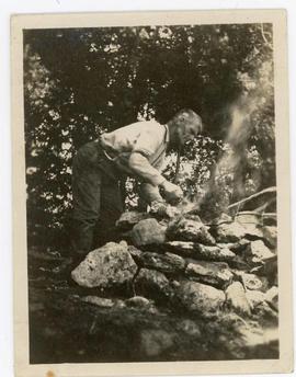 Snapshot of Del Wood at a cooking fire, inscribed au verso “At/Charleston Lake Canada/Week of Aug...