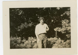 Woman standing against pine trees