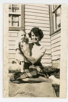 Photograph of woman holding a baby, also a negative